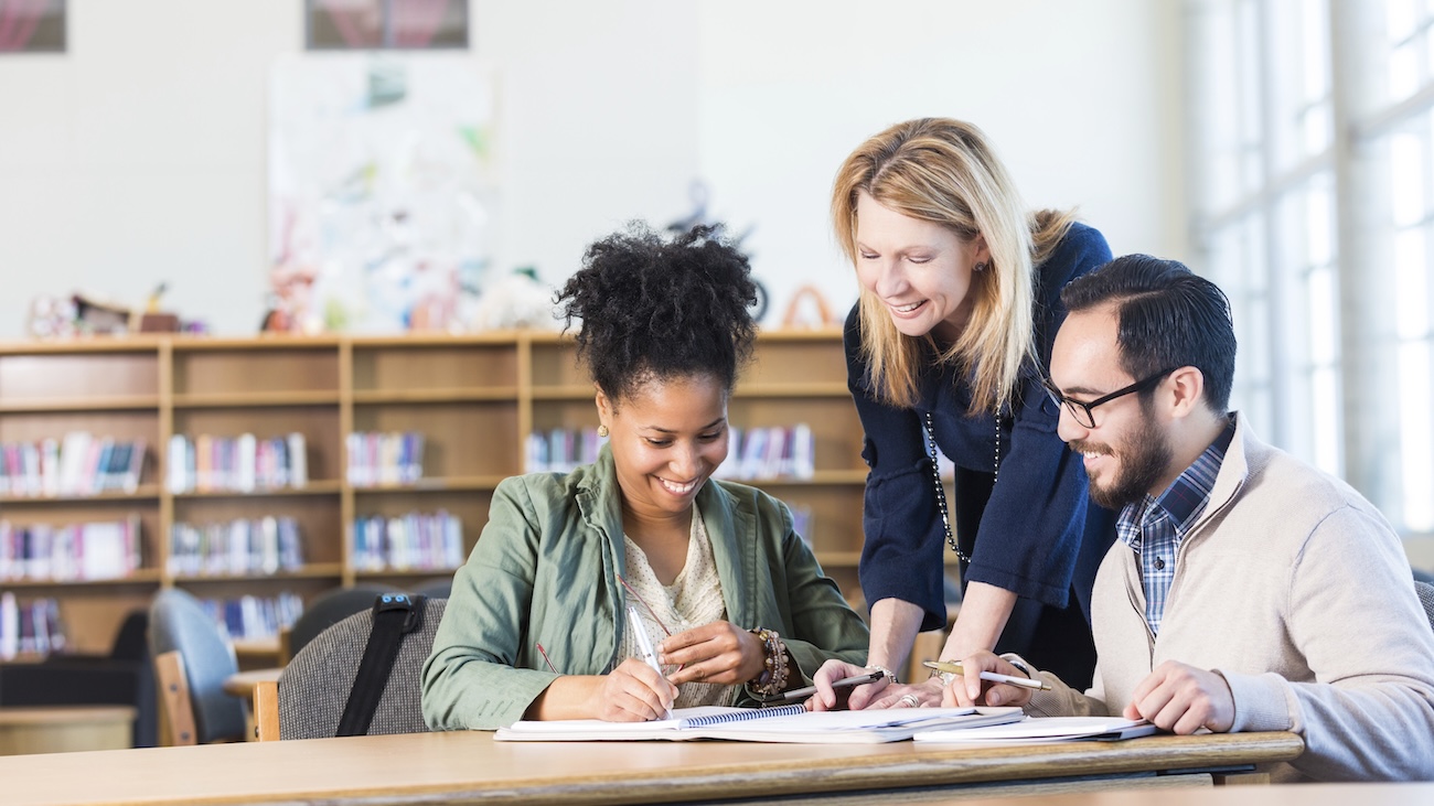 3 teacher talking in a library